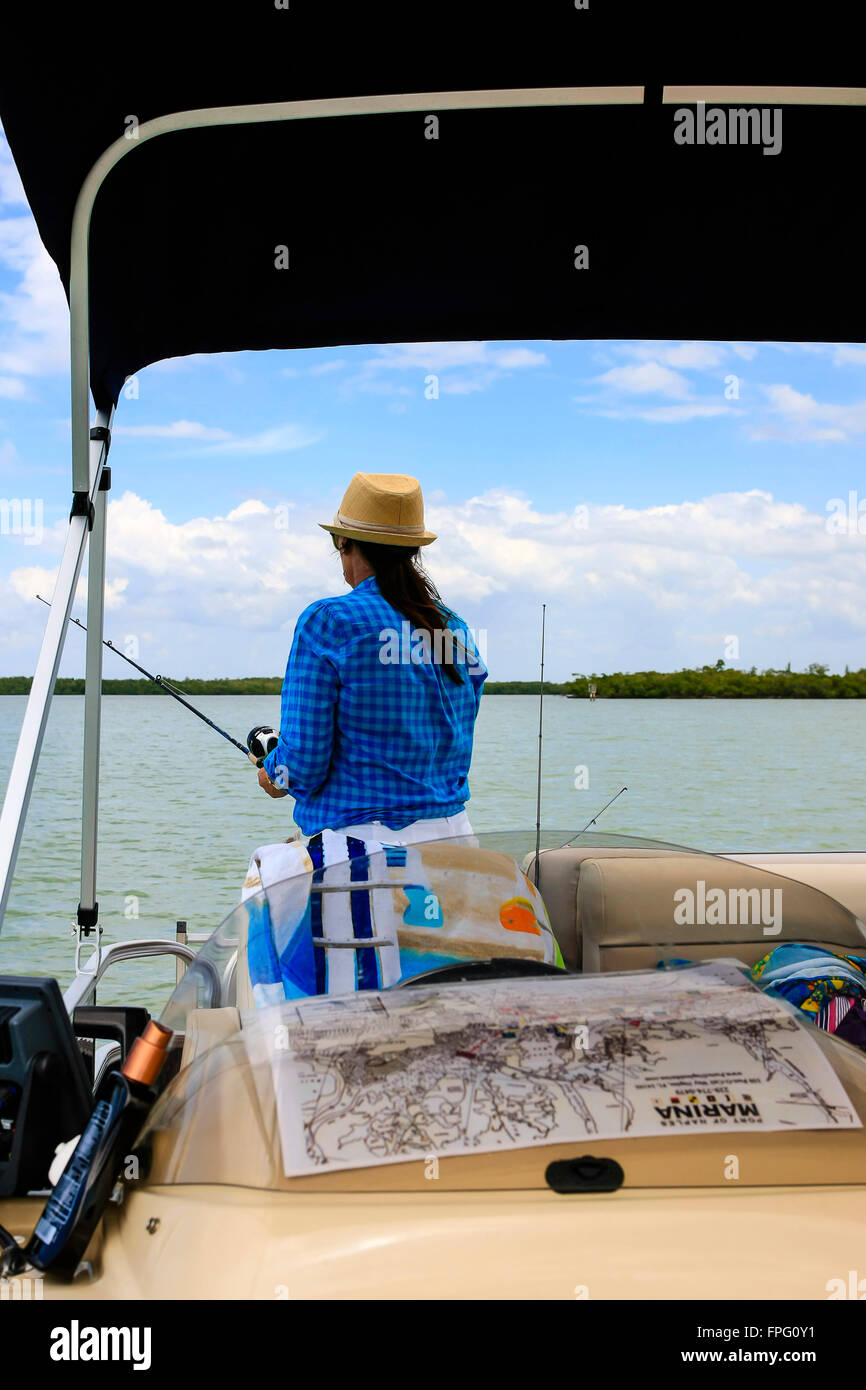 Erwachsene weibliche Angeln von einem Boot in Marco Bay, Florida Stockfoto