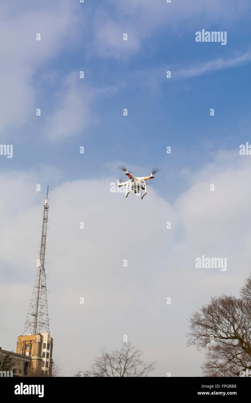 Quadrocopter Drohne in den Himmel schweben vor der BBC-Sendemast im Alexandra Palace in Nord-London, England Stockfoto