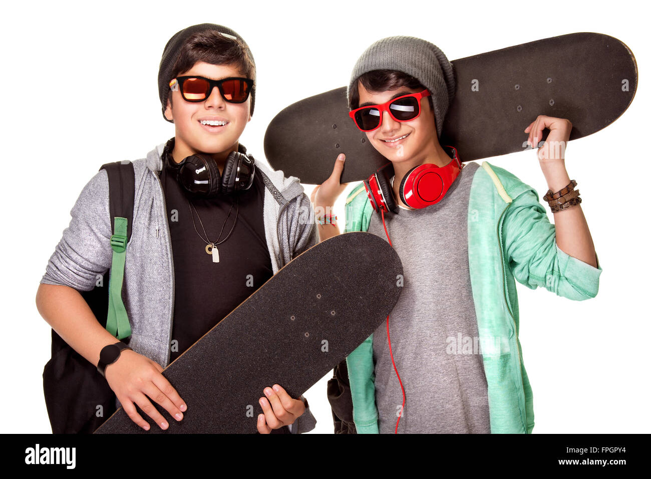 Porträt von zwei glücklichen Teen jungen mit Skateboards isoliert auf weißem Hintergrund, coolen trendigen Look, aktiven städtischen Lebensstil der Jugend Stockfoto