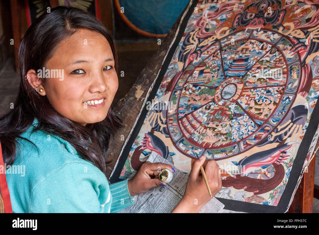 Nepal, Patan.  Junge Frau ein Thangka Malerei ein tibetisch-buddhistische Gemälde. Stockfoto