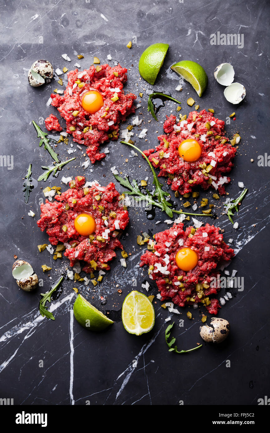 Beefsteak-Tatar mit Gewürzgurken und Zwiebeln auf dunklem Marmor Stockfoto