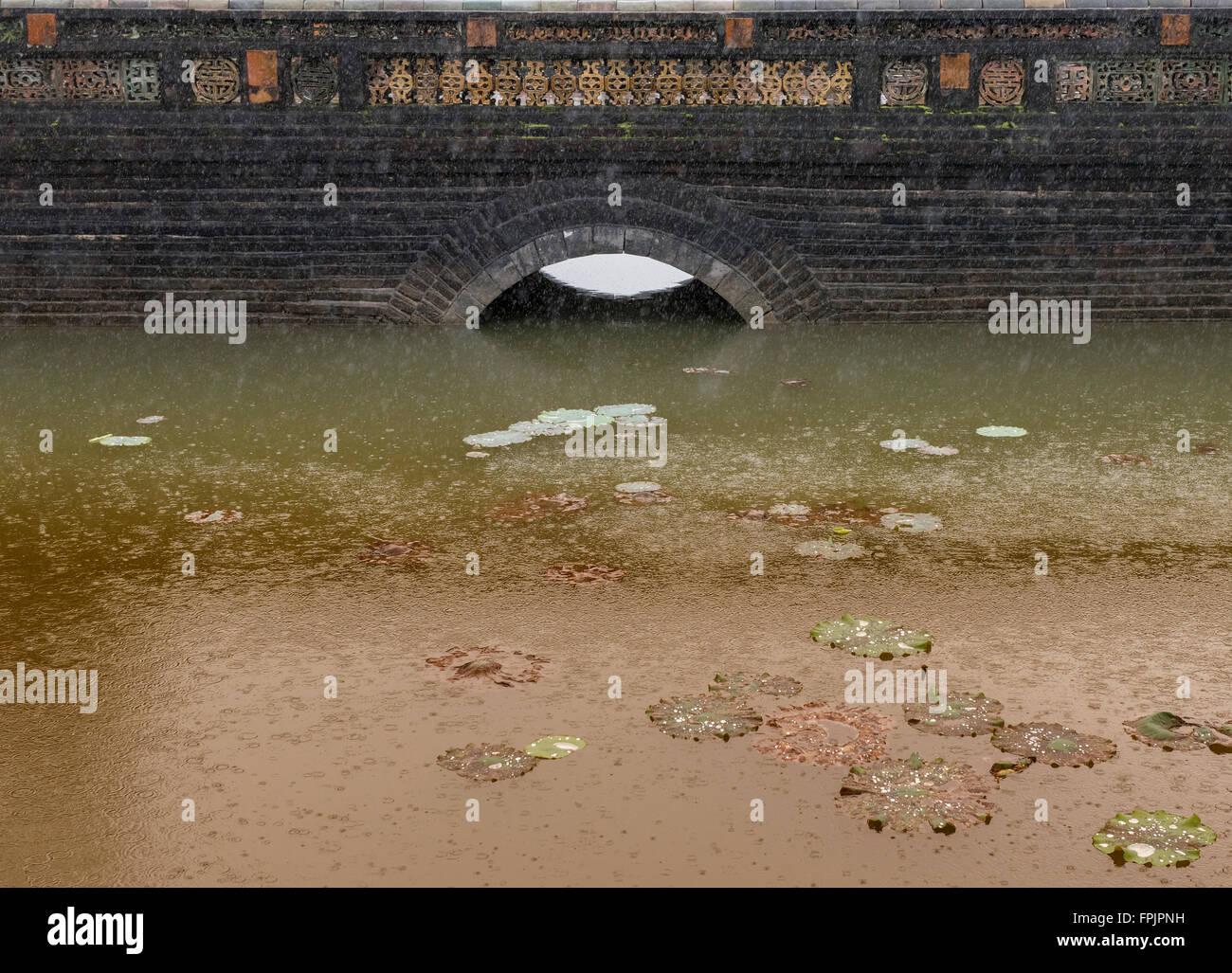 Brücke, Lotusblätter und Regen am Grab von Minh Mang, Vietnam Stockfoto