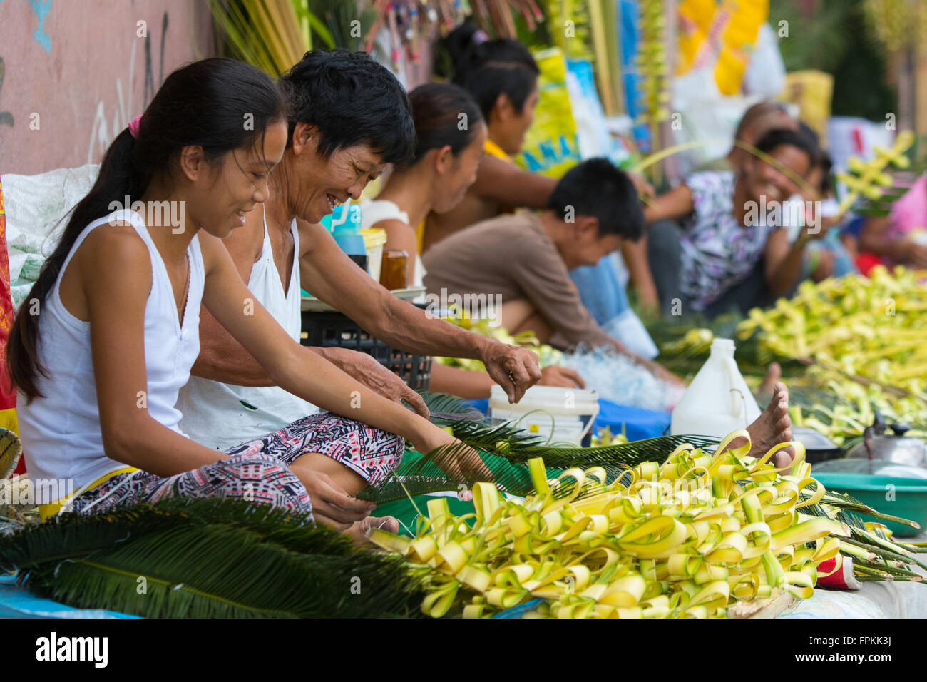 Innenstadt von Cebu City, Philippinen 19/3/2016.Filipino Anbieter sitzen entlang der Seitenstraßen eifrig, Kreuze aus Palm Fonds. Sie werden verkauft, christliche Gläubige Teilnahme an ihren jeweiligen katholischen Kirchen am folgenden Tag 20.03.2016 ist Palmsonntag. Bildnachweis: imagegallery2/Alamy Live-Nachrichten Stockfoto