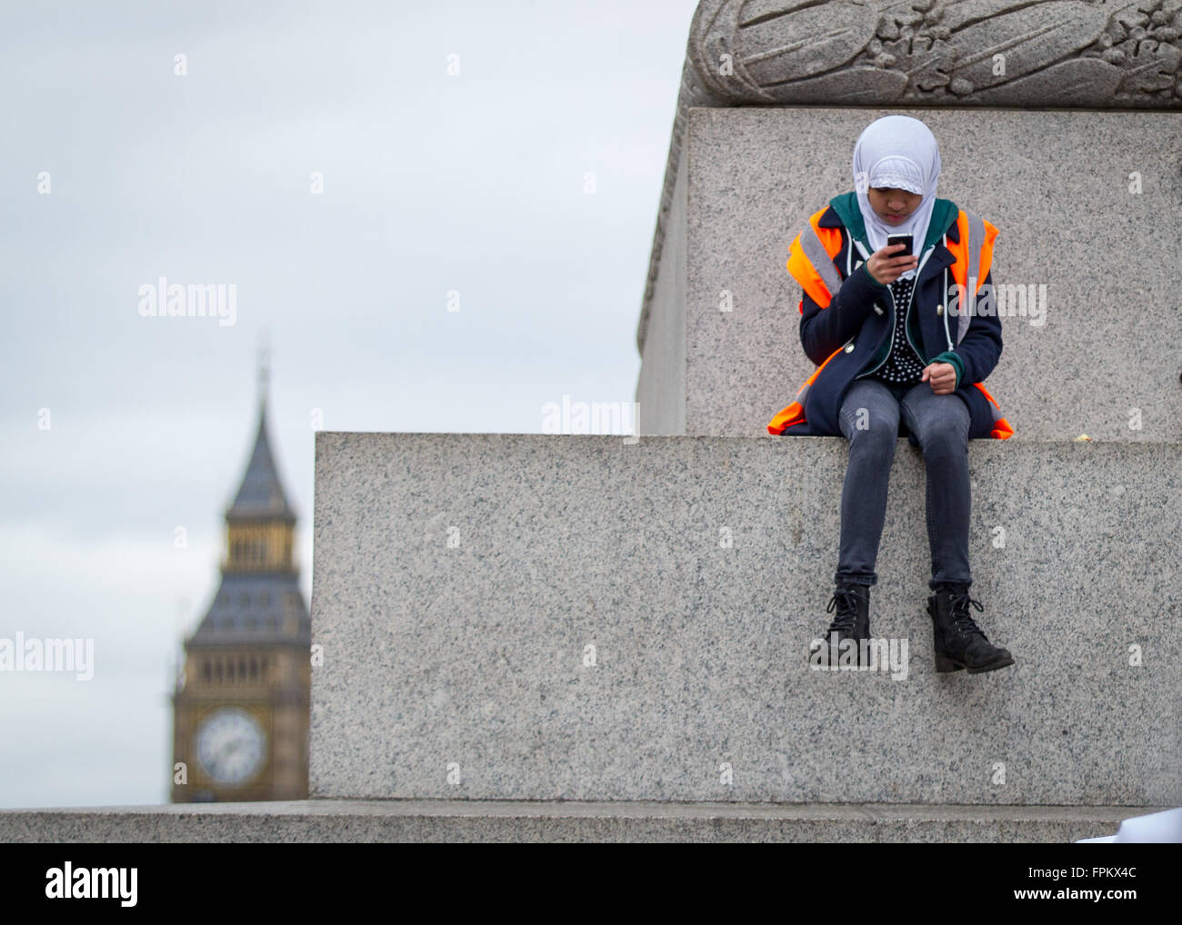 London, UK. 19. März 2016. UN-Anti-Rassismus, Flüchtlinge willkommen März und Rallye durch die Londoner Trafalgar Square. Protest-Veranstalter nimmt eine Pause auf Nelson Säule sitzend, während Referenten die Rallye befassen. Bildnachweis: Carol Moir/Alamy Live-Nachrichten Stockfoto