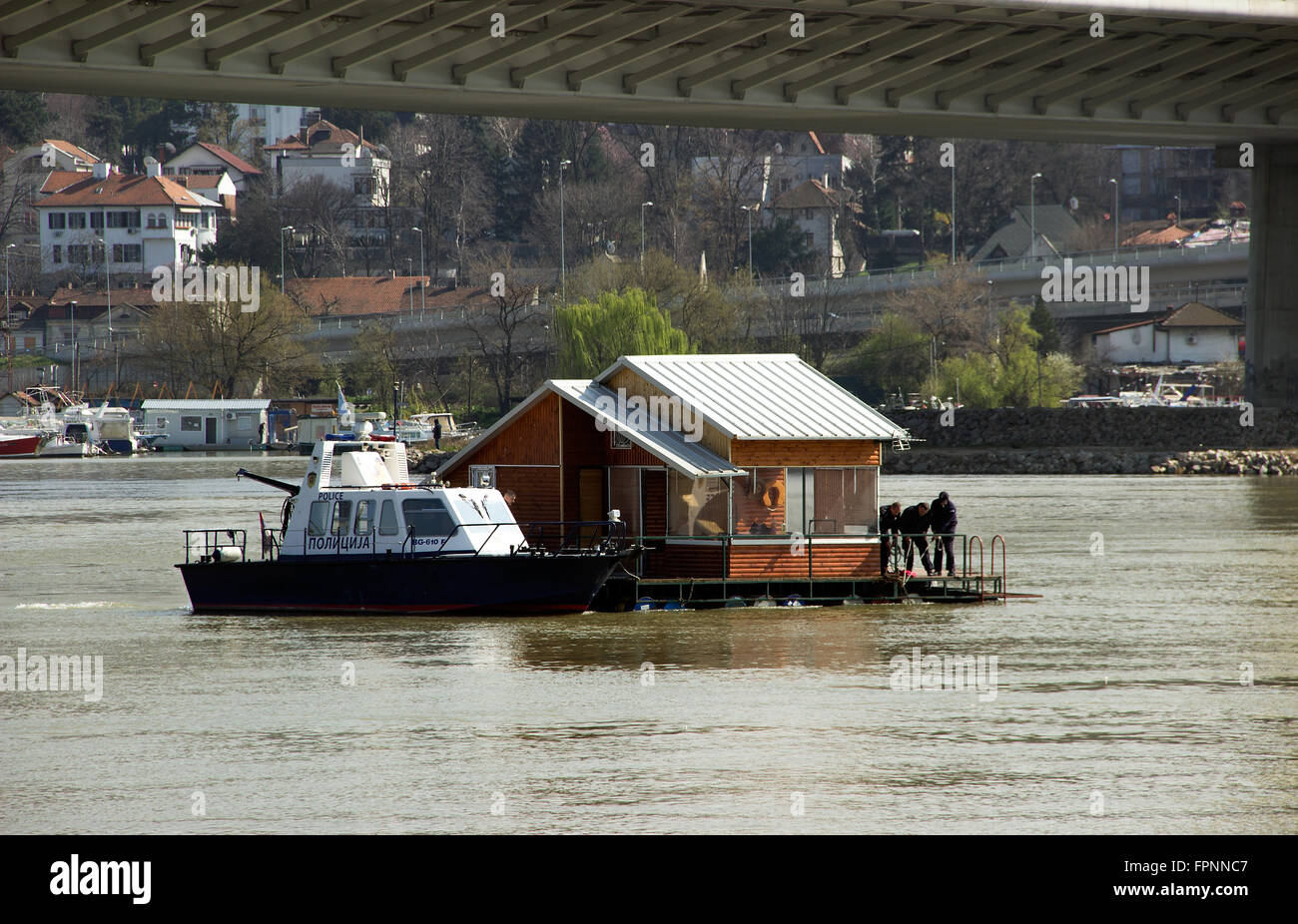 Fluss Sava, Belgrad - Mitglieder der Fluss Polizei bemühen sich um eine nicht angedockte Floßhaus in einem Flussströmungen kontrollieren Stockfoto