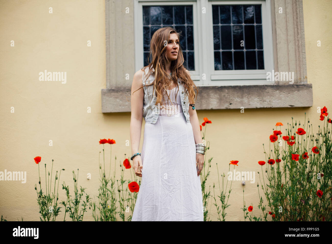 Junge Frau im weißen Kleid vor Kirche Stockfoto