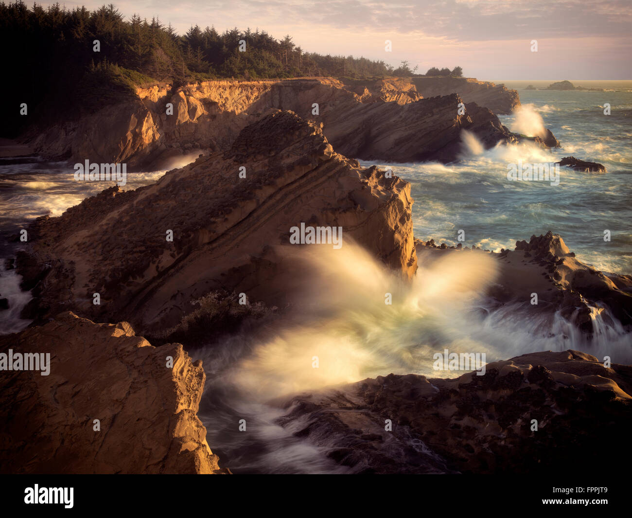 Wellen und untergehende Sonne Shore Acres State Park, Oregon Stockfoto