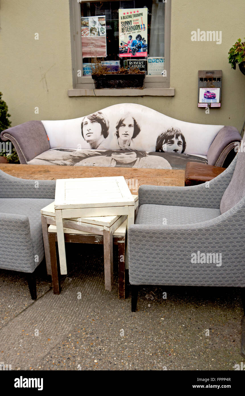Abgenutzte Möbel links vor einem Pub, einschließlich eine Sofa mit einem Foto von The Kinks auf den Stoff gedruckt. Stockfoto