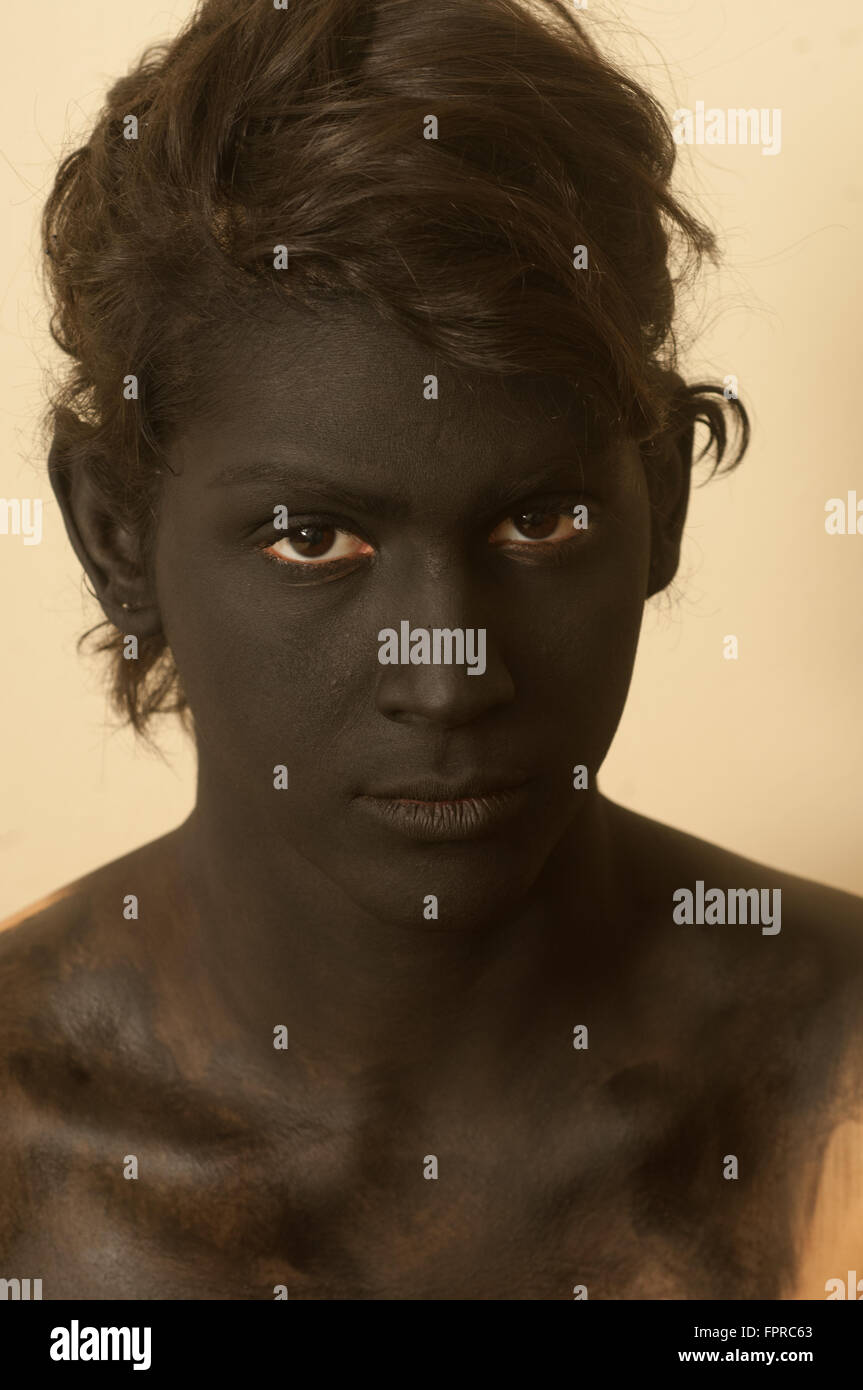 Junge weiße Mann gemalt sein Gesicht und Körper mit braunen Make-up. Stockfoto