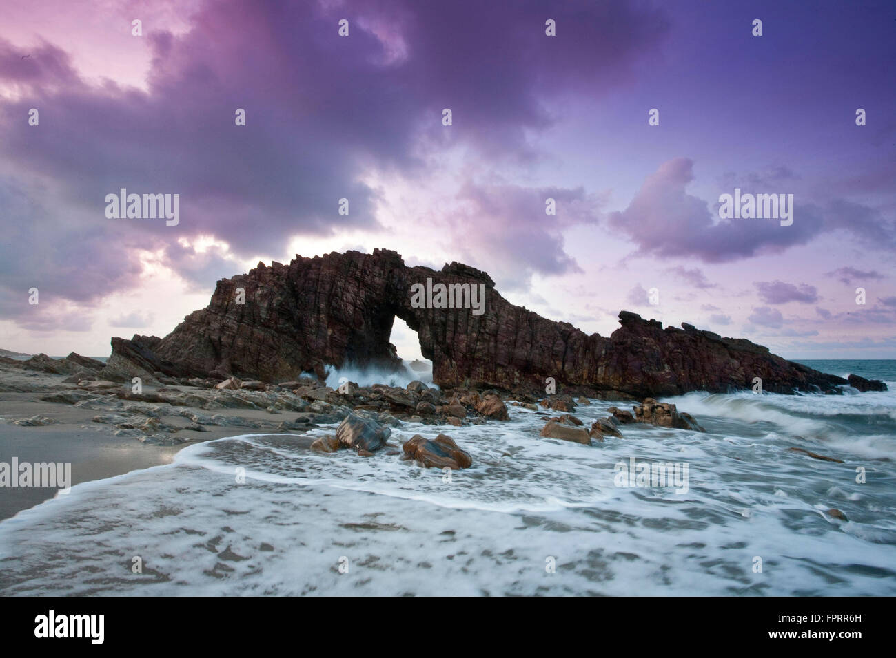 Jericoacoara, Brasilien, Ceara, Sonnenuntergang am Pedra Furada Felsen; brechenden Wellen, Felsbogen Stockfoto