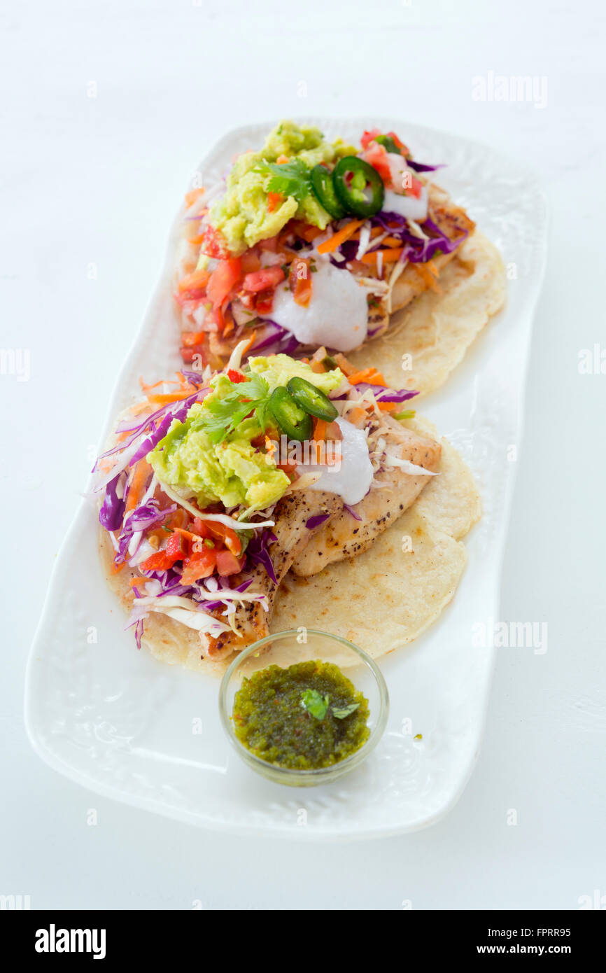 Neutraler Schuss von gesunden, Bio-, Gourmet-Huhn und Avocado Burrito serviert auf traditionellen Maismehl Tortillas mit scharfer Chili-Pfeffer-Sauce Stockfoto