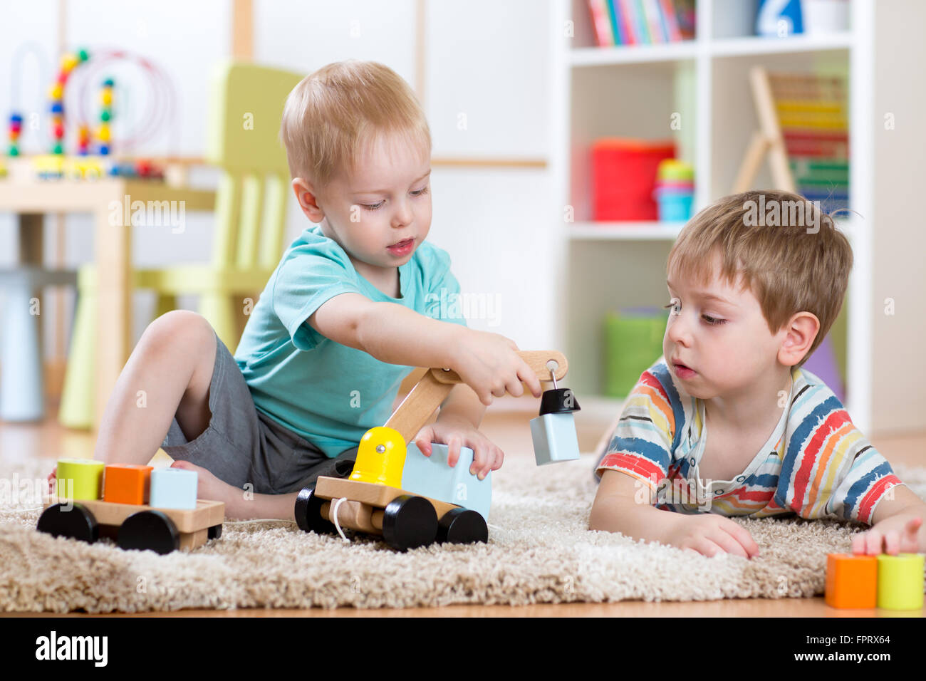 Kinder spielen mit Holz Auto zu Hause oder Kindertagesstätten.  Pädagogische Spielwaren für Vorschule und Kindergarten Kind. Stockfoto