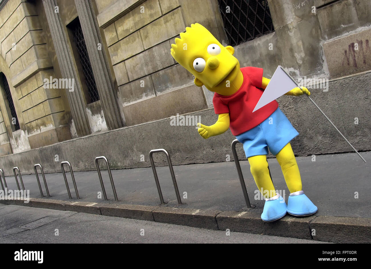 Lebensgröße Bart Simpson cartoon Charakter stützte sich auf Fahrradträger mit leeren dreieckigen Flagge in der hand Stockfoto