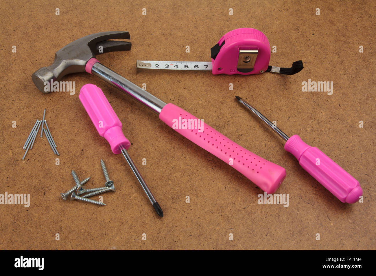 Rosa nützliche Tools auf einer Holzoberfläche Stockfoto