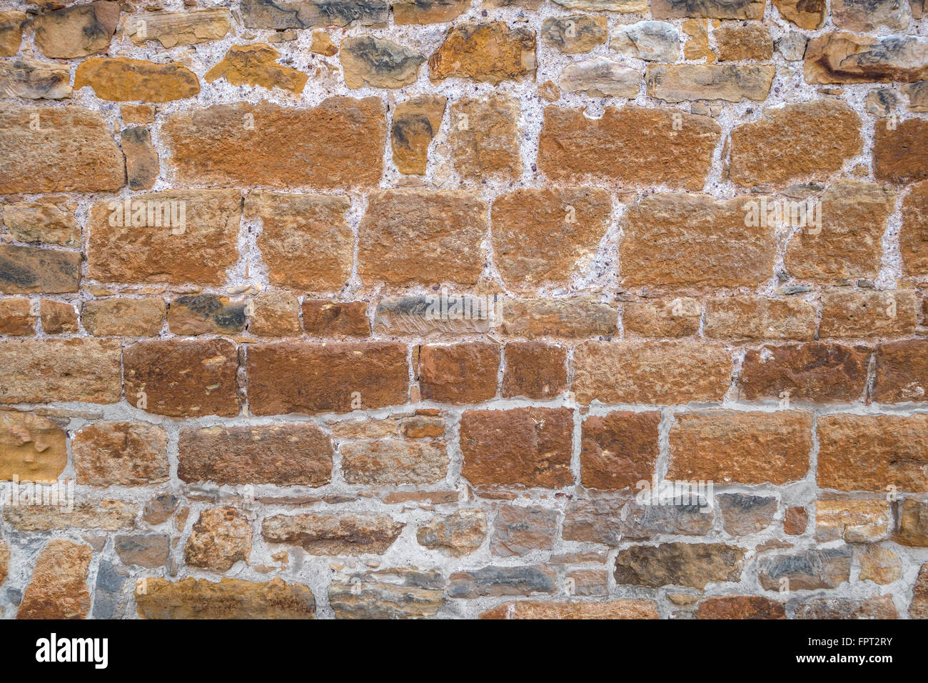 Alte braune Steinmauer von groben Natursteinen mit teilweise bläulichen Nuancen, genommen in Nahaufnahme Stockfoto