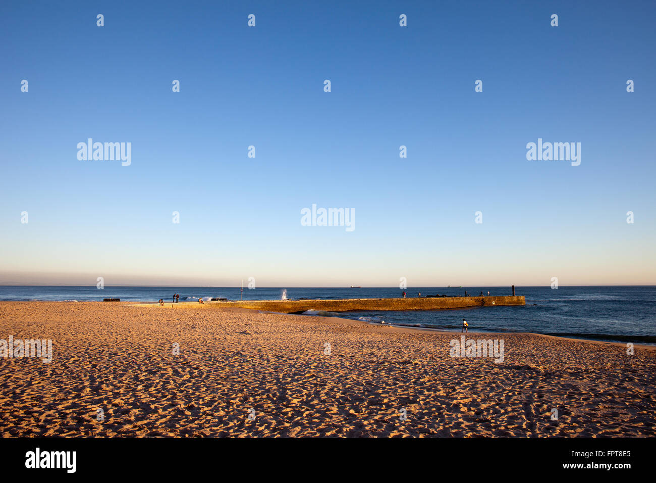 Strand bei Sonnenuntergang mit Pier vom Atlantischen Ozean, Estoril, Portugal Stockfoto