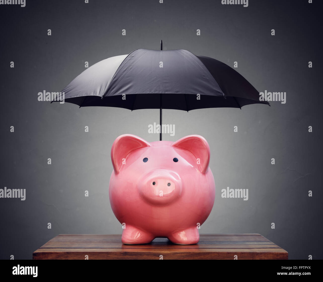 Sparschwein mit Regenschirm Stockfoto