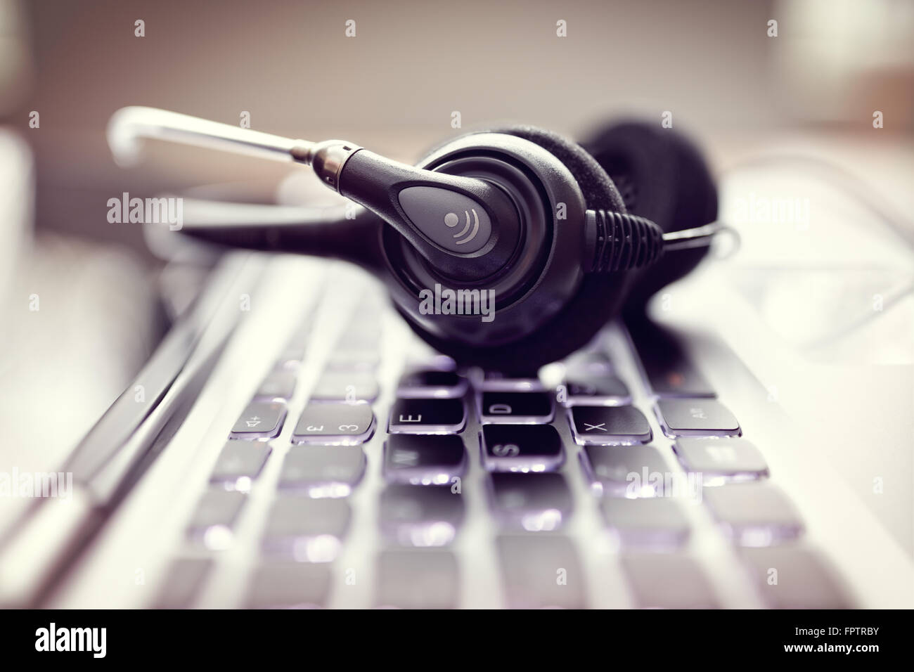 VoIP-Kopfhörer auf Laptop-Computer-Tastatur Stockfoto