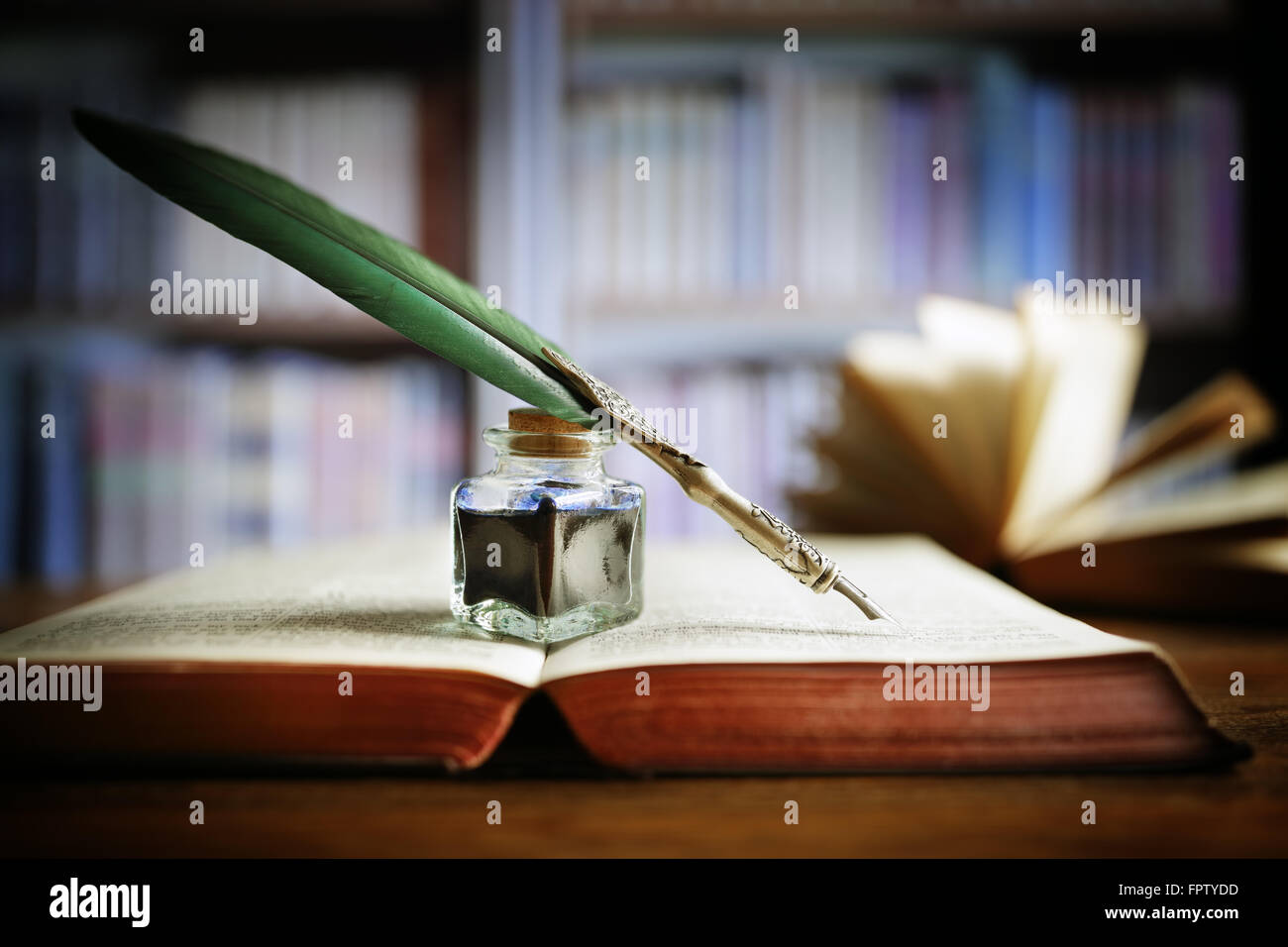 Federkiel auf ein altes Buch in einer Bibliothek Stockfoto