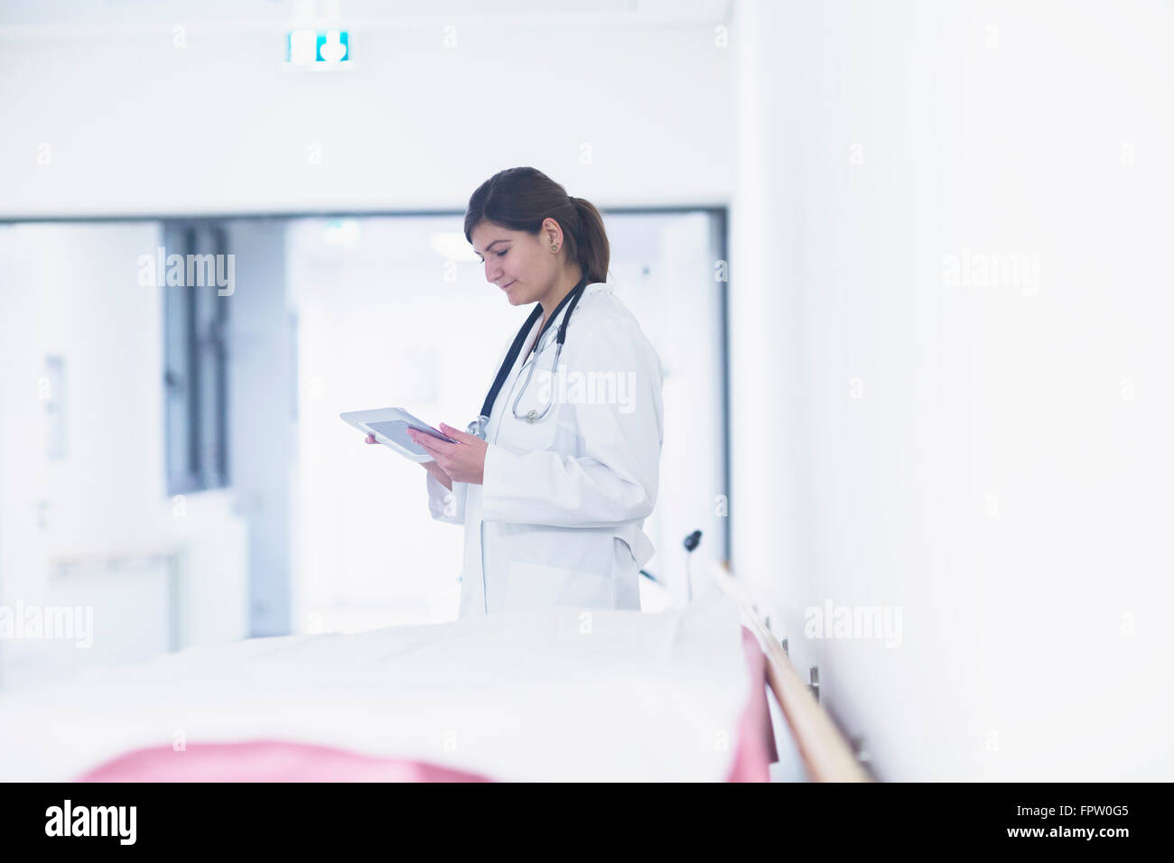 Junge Ärztin, die mit einem digitalen Tablet im Krankenhaus, Freiburg Im Breisgau, Baden-Württemberg, Deutschland Stockfoto