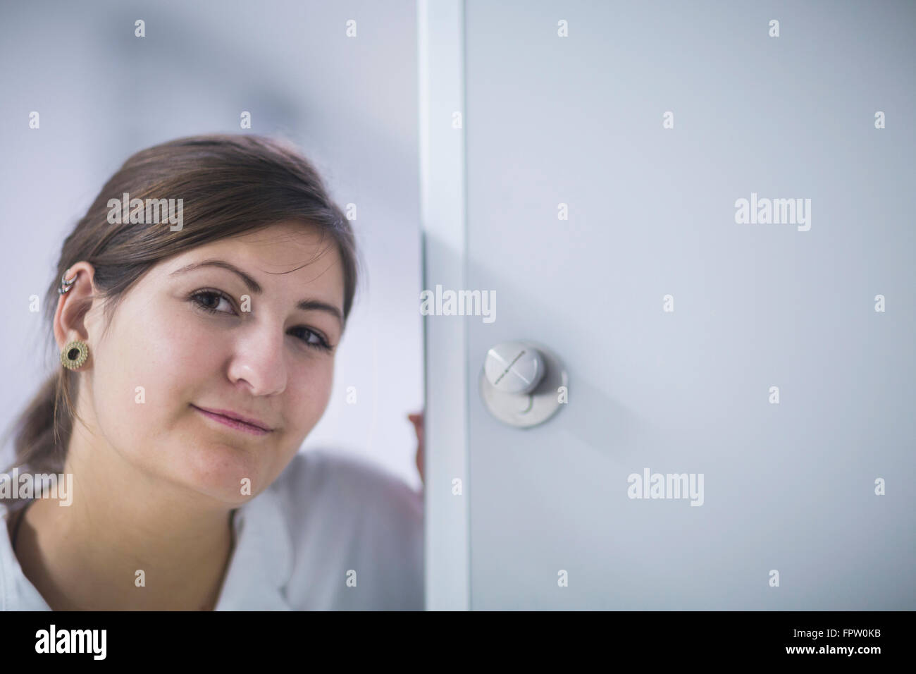 Porträt einer jungen Ärztin an Tür im Krankenhaus, Freiburg Im Breisgau, Baden-Württemberg, Deutschland Stockfoto