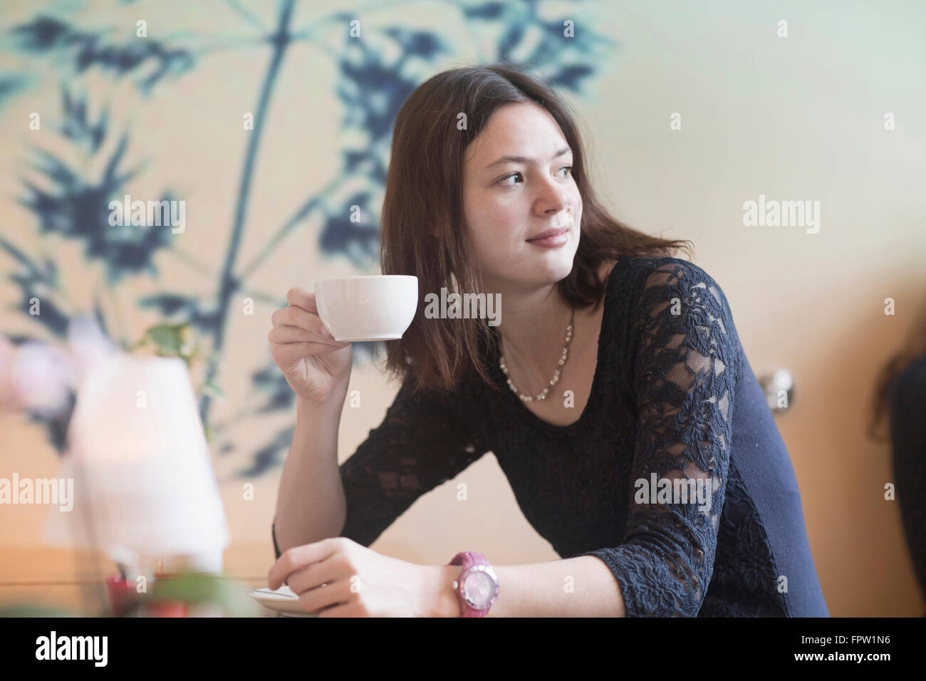 Junge Frau trinken Kaffee in Coffee-Shop, Freiburg Im Breisgau, Baden-Württemberg, Deutschland Stockfoto