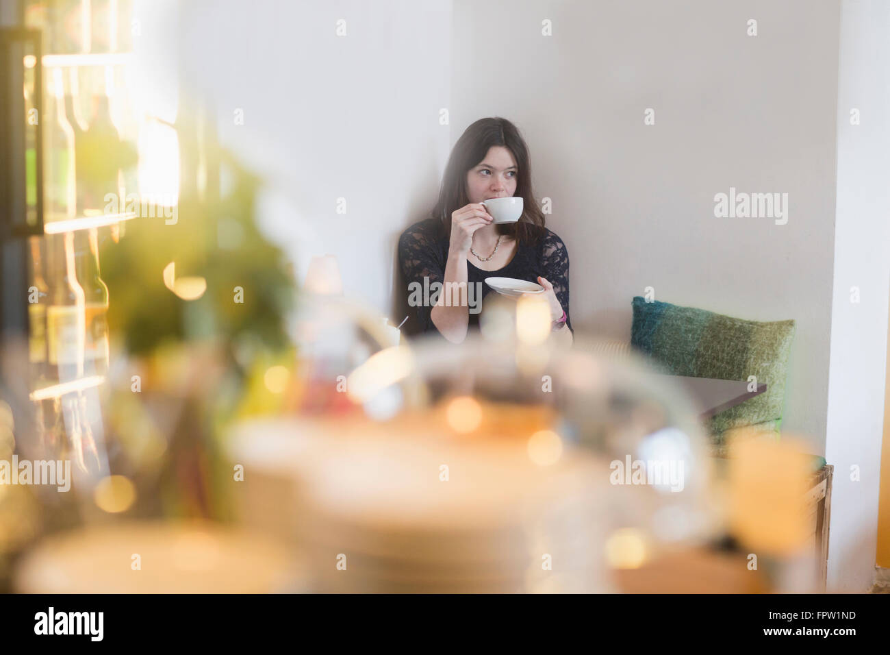 Junge Frau trinken Kaffee in Coffee-Shop, Freiburg Im Breisgau, Baden-Württemberg, Deutschland Stockfoto