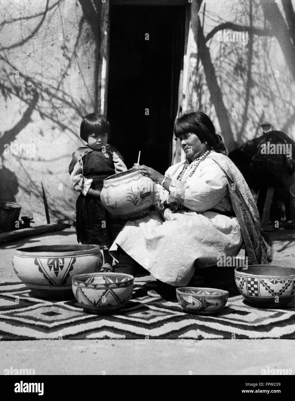 1930ER JAHRE KIND BEOBACHTEN INDIANER INDIANERIN KÜNSTLER DEKORATION KERAMIK COCHITI PUEBLO NEW MEXICO USA Stockfoto