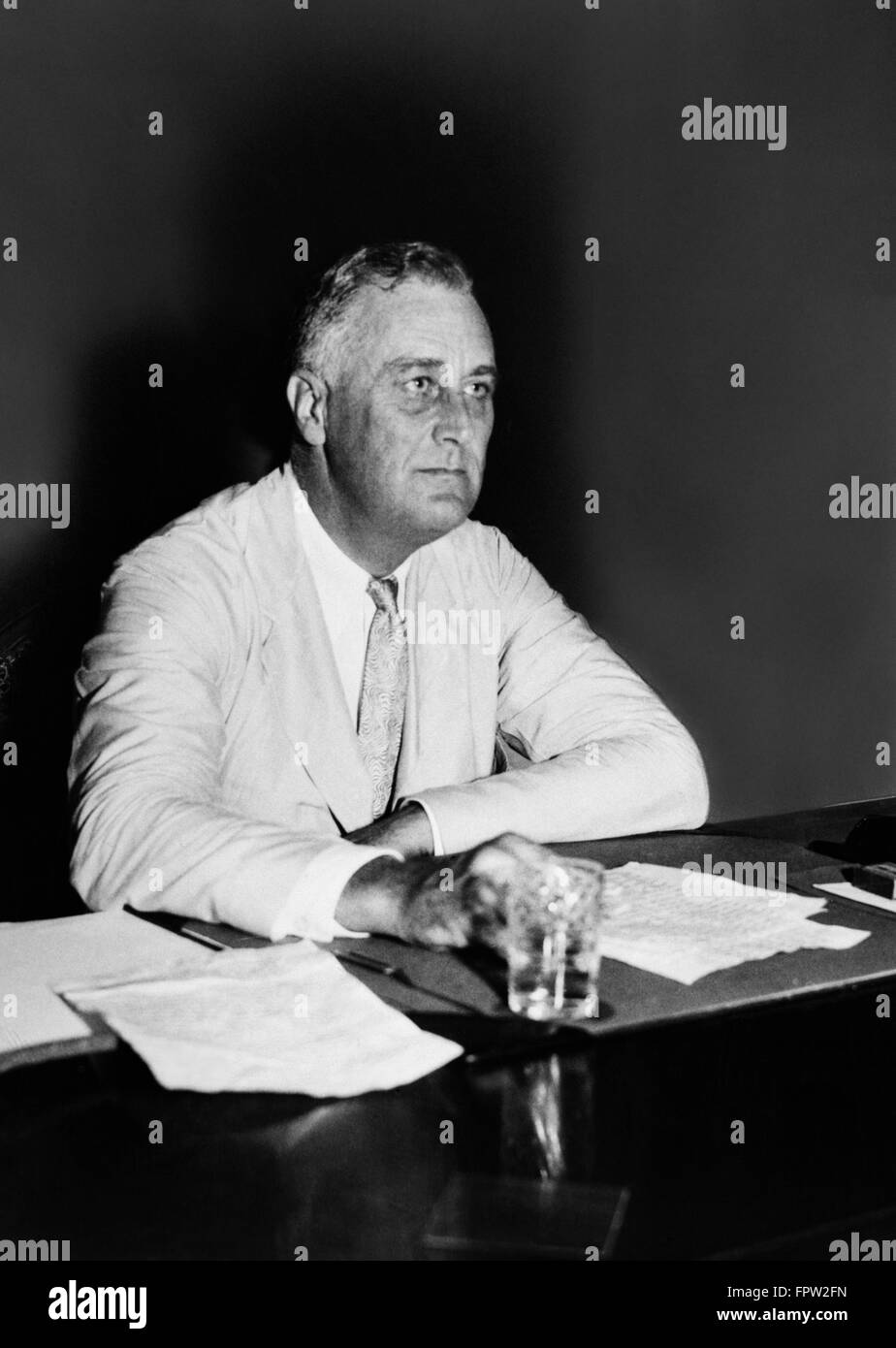 1930S 1940S PORTRÄT FRANKLIN DELANO ROOSEVELT FDR 32. US-PRÄSIDENT SITZEN AM SCHREIBTISCH MIT PAPIEREN Stockfoto