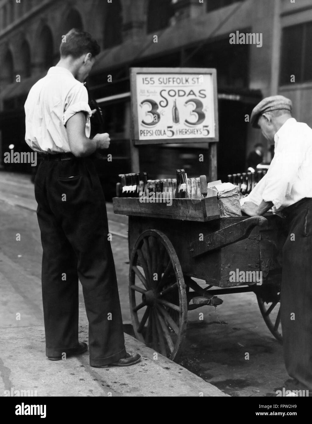 1930ER JAHRE JUNGER MANN KUNDEN- UND BÜRGERSTEIG STRAßE VENDER MIT HANDKARREN VERKAUF LIMONADEN FÜR 3 CENT & 5 CENT FÜR PEPSI COLA Stockfoto