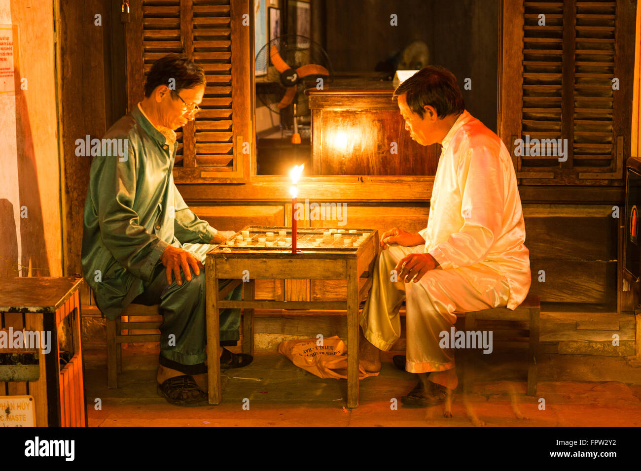 Männer in das Licht einer Kerze ein Brettspiel, Altstadt von Hoi an, Vietnam Stockfoto