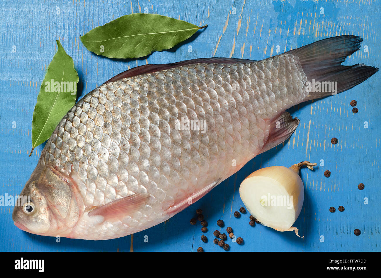 Roher Fisch auf blauem Untergrund aus Holz Stockfoto