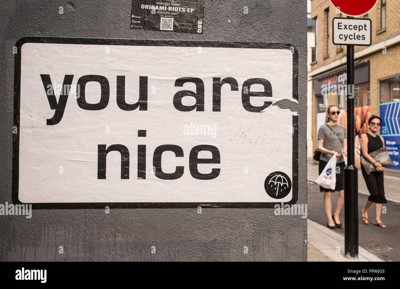 Weiße Tafel mit den Worten "Sie sind schön" an einer Wand in einer Straße in London. Zwei Frau mit Sonnenbrille zu Fuß neben ihm. Stockfoto