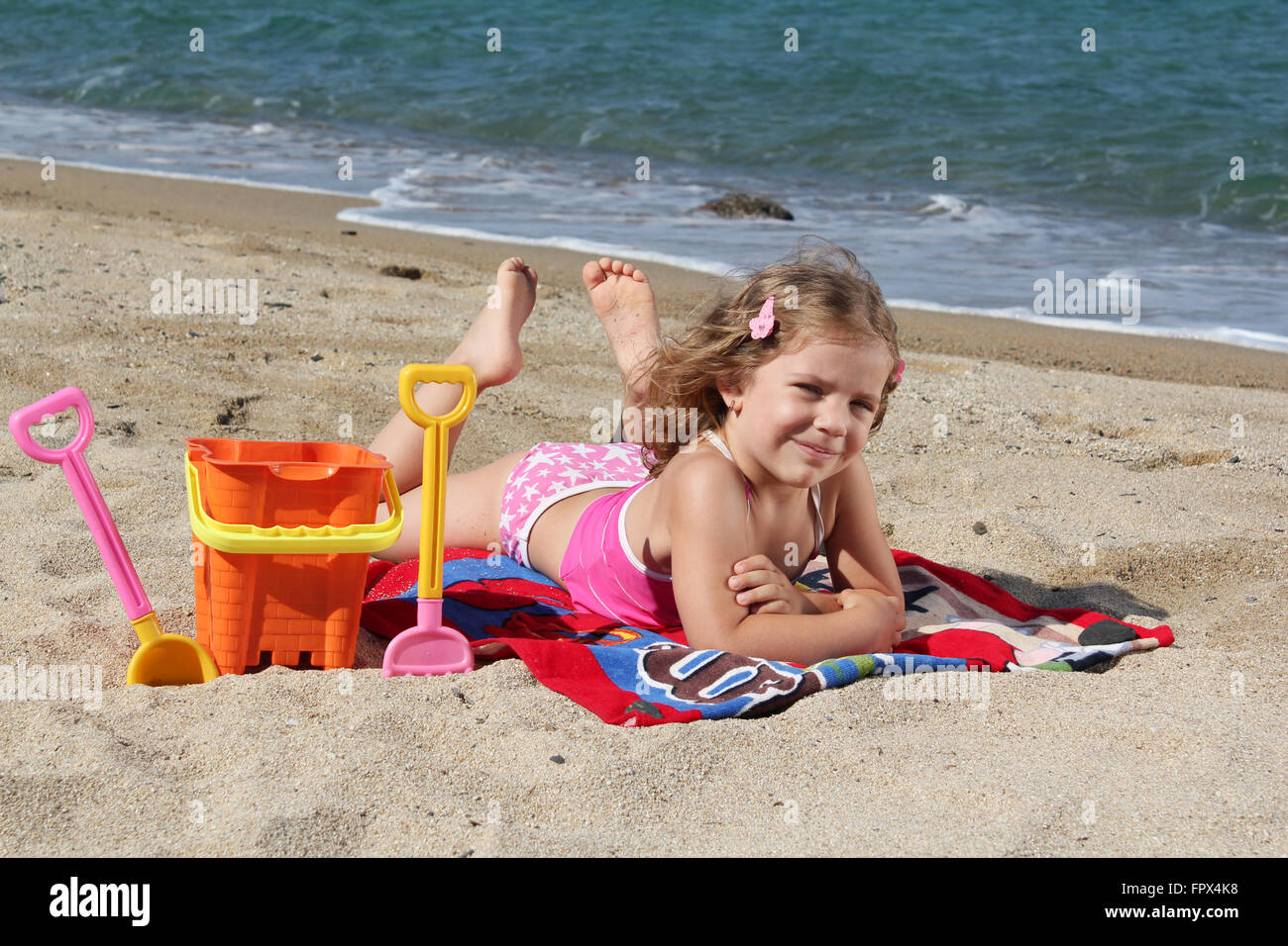 kleines Mädchen am Strand liegen Stockfoto