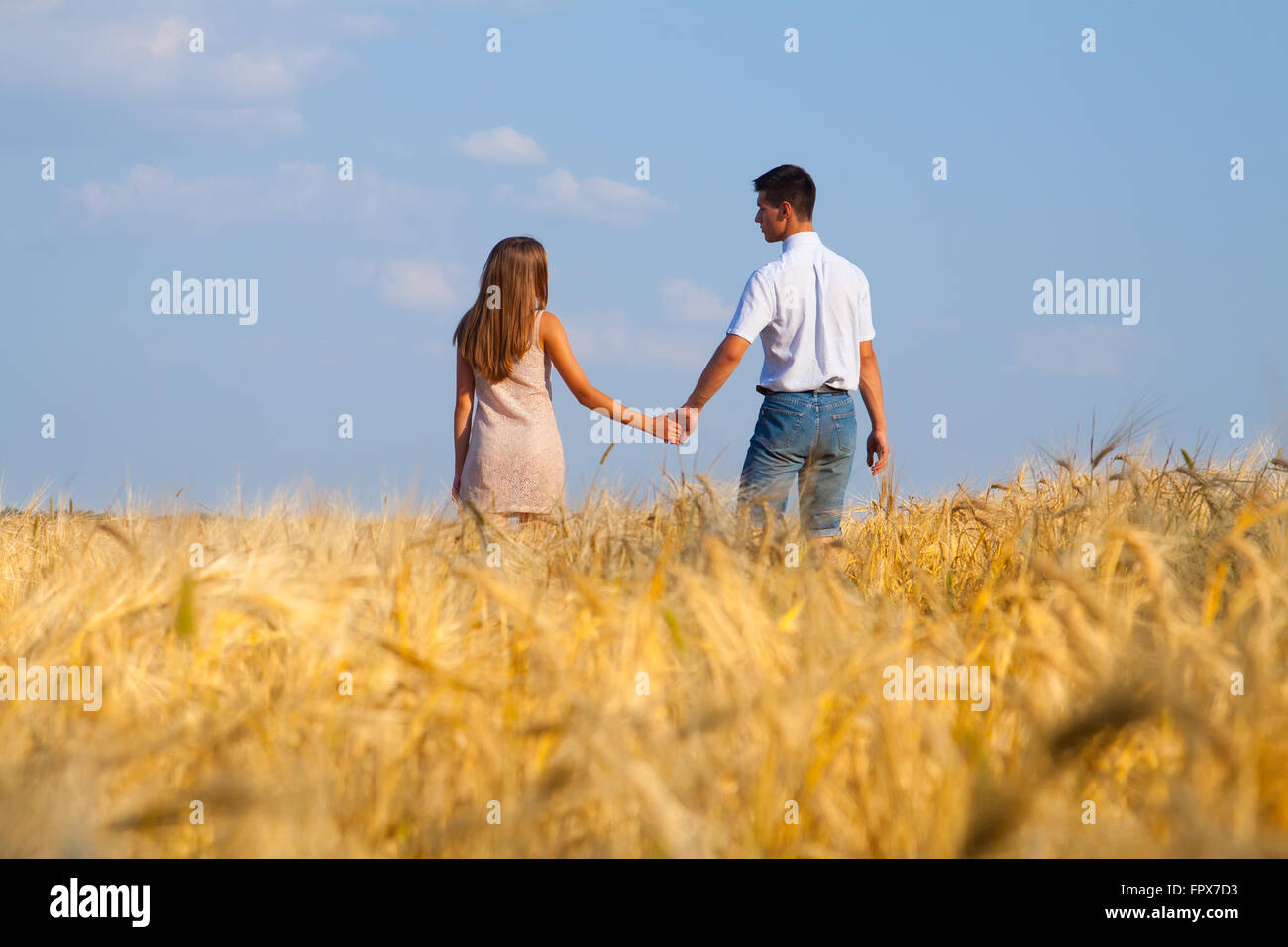 Junges Paar zu Fuß durch Weizenfeld Stockfoto