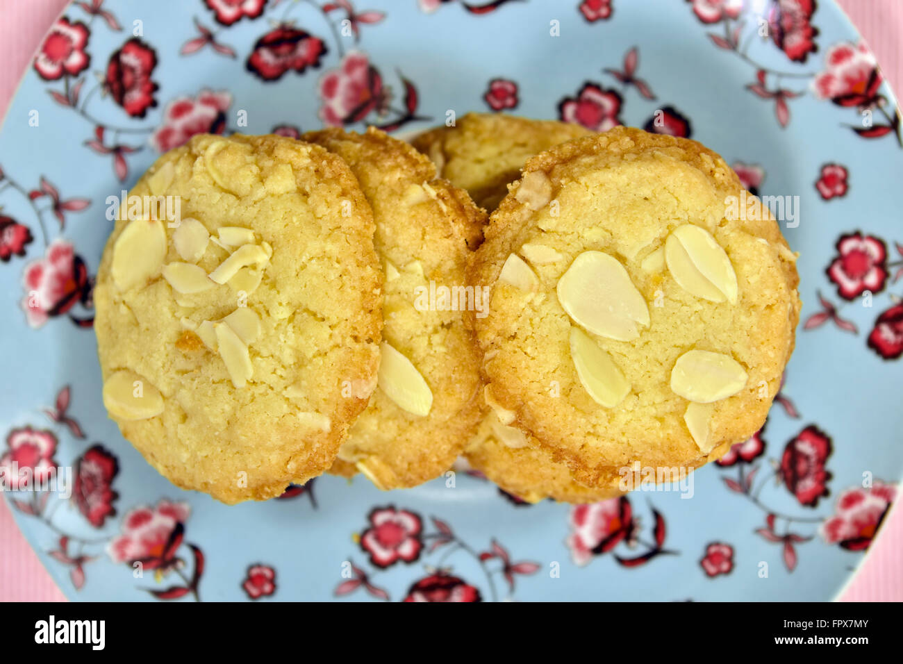 Hausgemachte Mandel Cookies auf ziemlich rosa gemusterten Teller Stockfoto