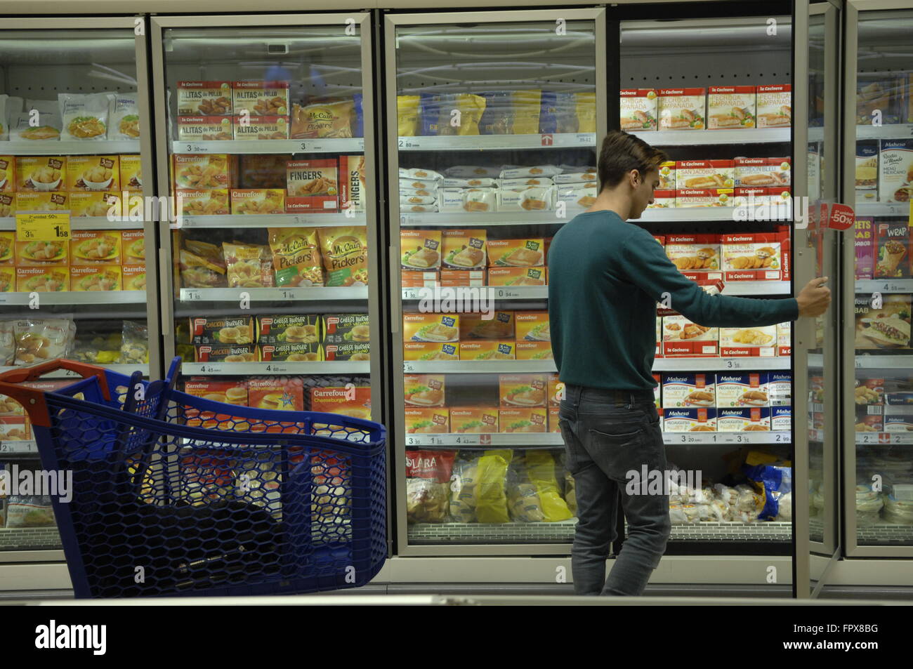 Kunden betrachten produzieren im Bereich Tiefkühlkost der Carrefour-Supermarkt Malaga Spanien. Stockfoto