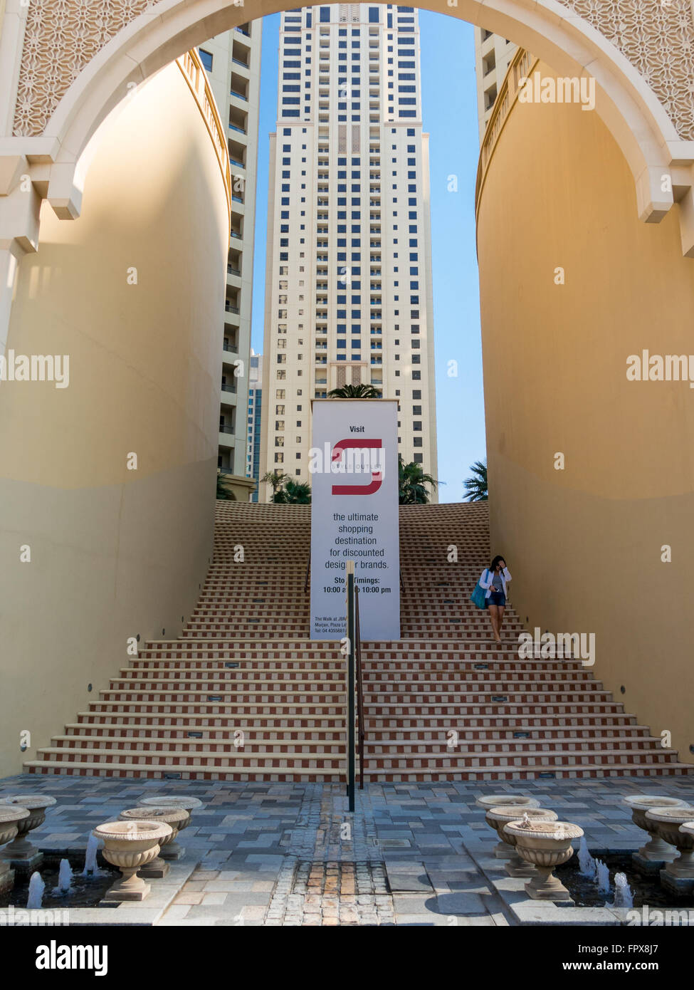 Frau, die Treppen hinunter Shopping Center The Walk in der Marina von Dubai, Vereinigte Arabische Emirate Stockfoto