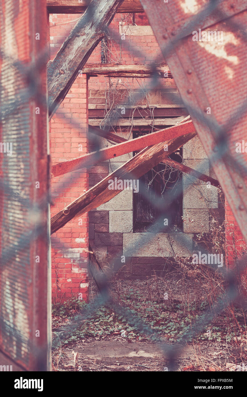 Details des architektonischen Verfall durch einen Maschendrahtzaun gesehen. Stockfoto