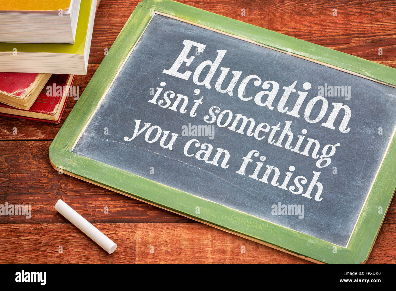 Bildung ist nicht etwas, was Sie beenden kann - motivierende Erinnerung auf einer Schiefertafel Tafel mit weißer Kreide und einen Stapel Bücher Stockfoto