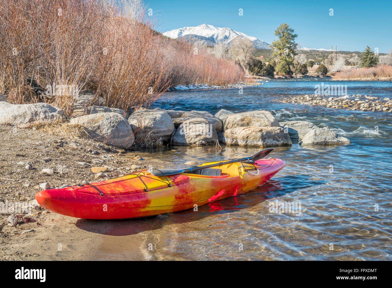 Wildwasser-Kajak mit einem Paddel auf einem Flussufer - Arkansas River bei Big Bend in der Nähe von Poncha Springs, Colorado in Winterlandschaft Stockfoto