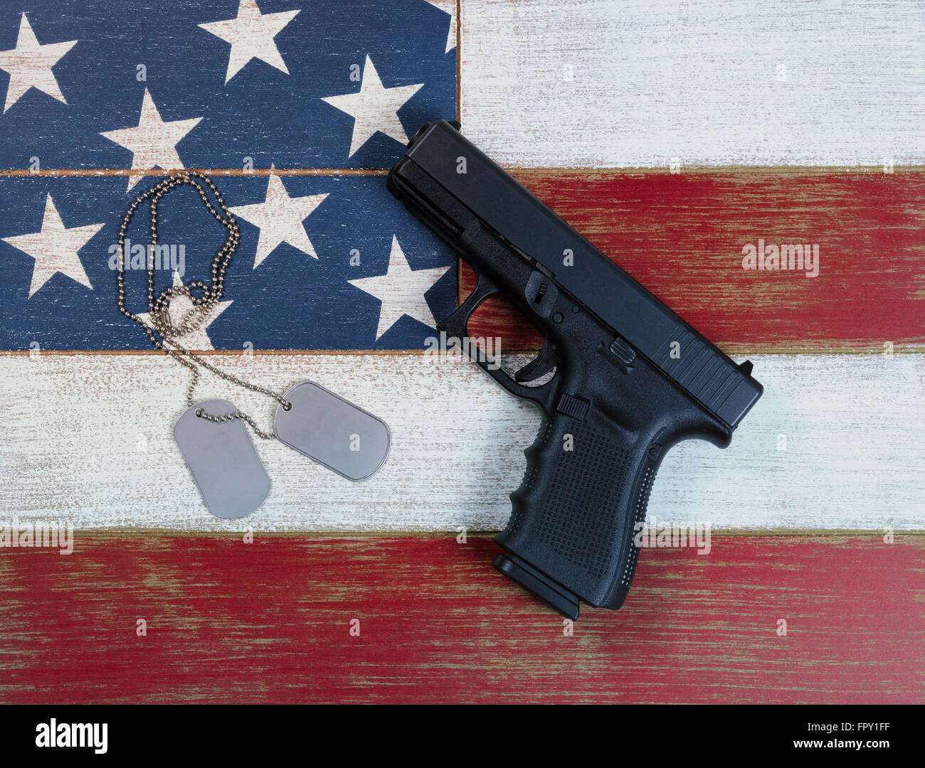 Pistole und militärische Identifikation Tags am Anfang verblasst USA Flagge Farben rot, weiß und blau auf Altern-Boards. Stockfoto