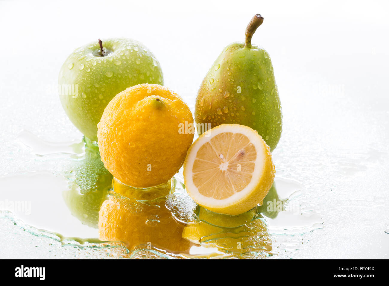 Apfel, Birne und Zitrone mit Wassertropfen reflektiert Stockfoto