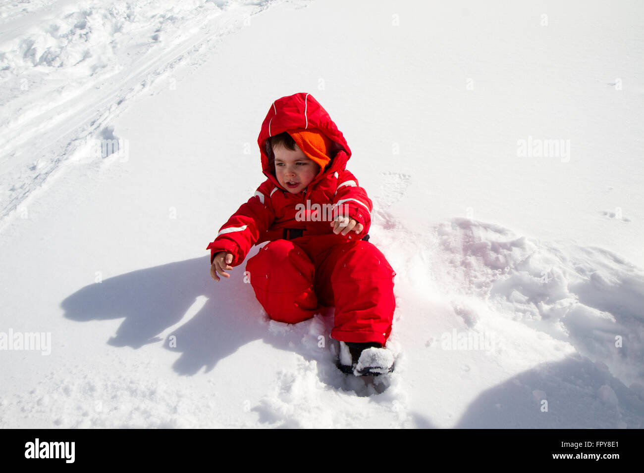 Kind mit roten Skianzug im Schnee hautnah Stockfoto