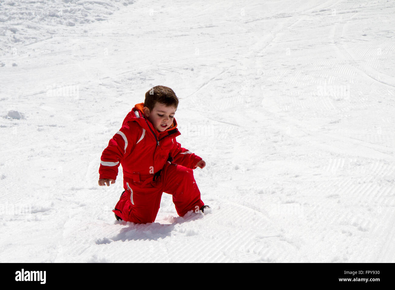 Kind mit roten Skianzug im Schnee hautnah Stockfoto