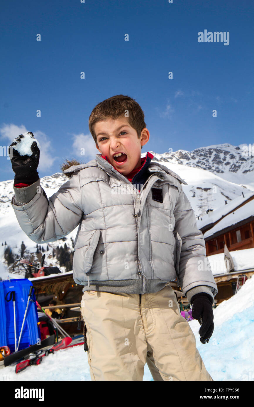Nahaufnahme Kind ziehen Schneeball mit blauem Himmelshintergrund Stockfoto