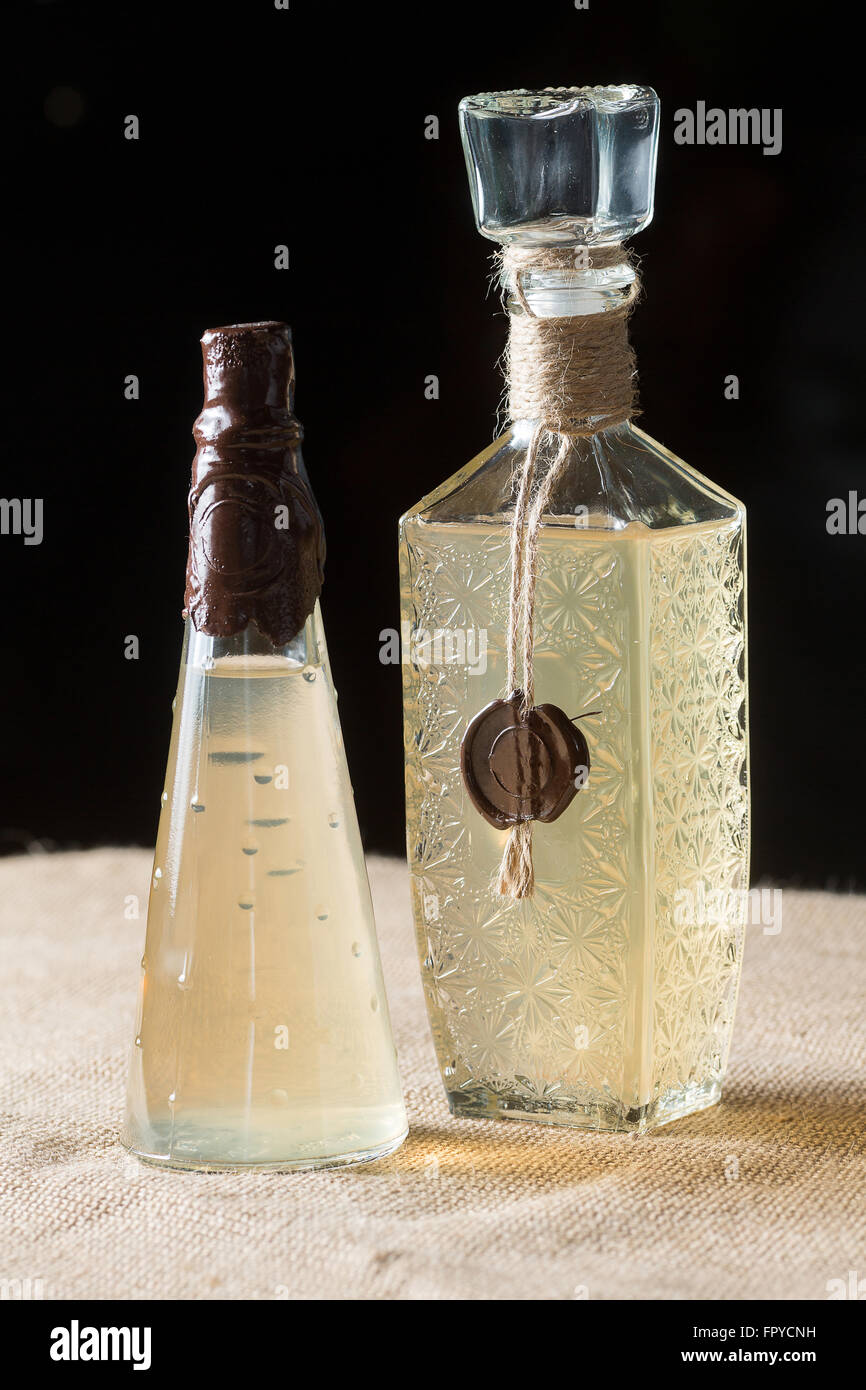 Zwei Flaschen Hellgelbe Flüssigkeit mit Wachs versiegelt Stockfoto
