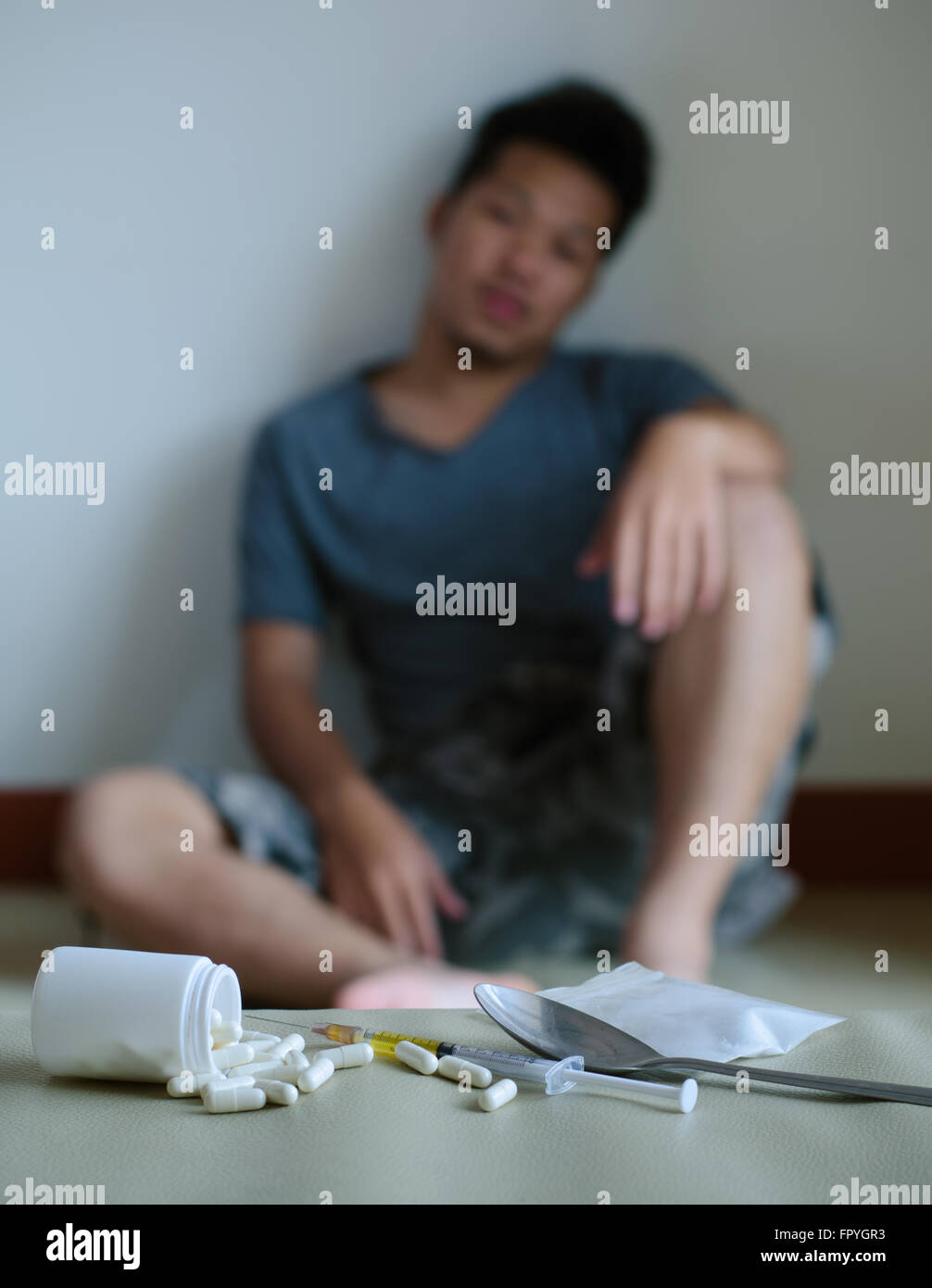 Drogen und Drogenabhängiger, sitzt im Hintergrund Stockfoto