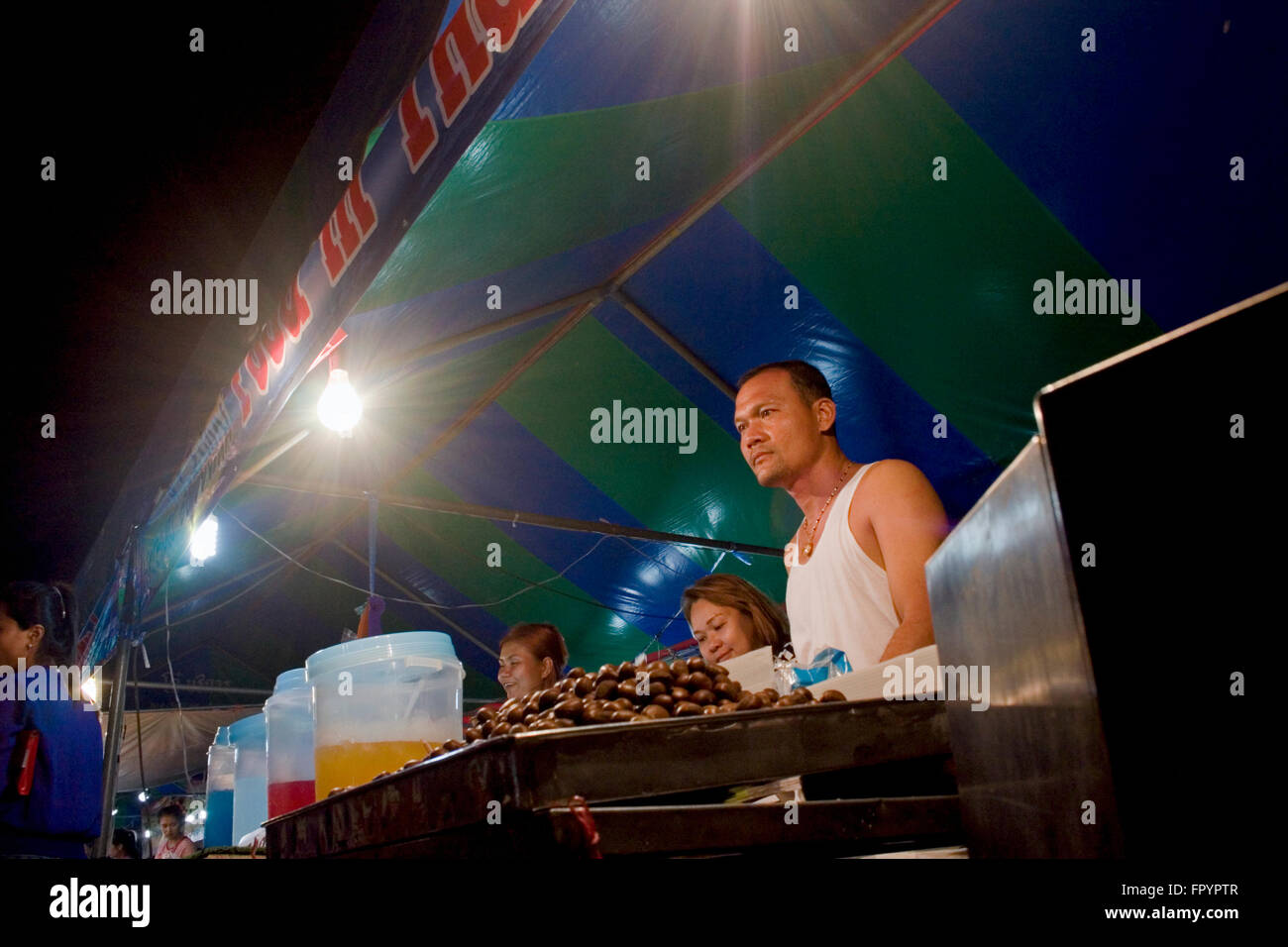 Ein Mann verkauft Lebensmittel aus Thailand an einer Straßenecke Messe in Kampong Cham, Kambodscha. Stockfoto