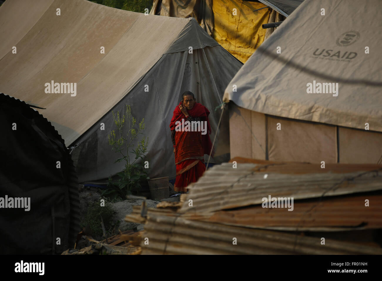 Bhaktapur, Nepal. 20. März 2016. Eine nepalesische älteren Bürger geht es vorbei an behelfsmäßigen Zelten vor Prinz Harrys Ankunft, Erdbeben-Überlebenden zu besuchen, denen wohnen in behelfsmäßigen Zelten vertrieben durch Erdbeben, die letztes Jahr in Byasi, Bhaktapur, Nepal auf Sonntag, 20. März 2016 aufgetreten sind. © Skanda Gautam/ZUMA Draht/Alamy Live-Nachrichten Stockfoto